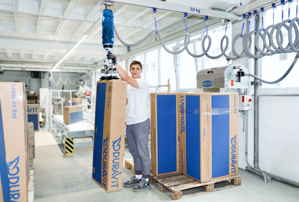 Ready for storage: the JumboFlex vacuum tube lifter lifts the large cardboard boxes from the roller conveyor onto the pallet.